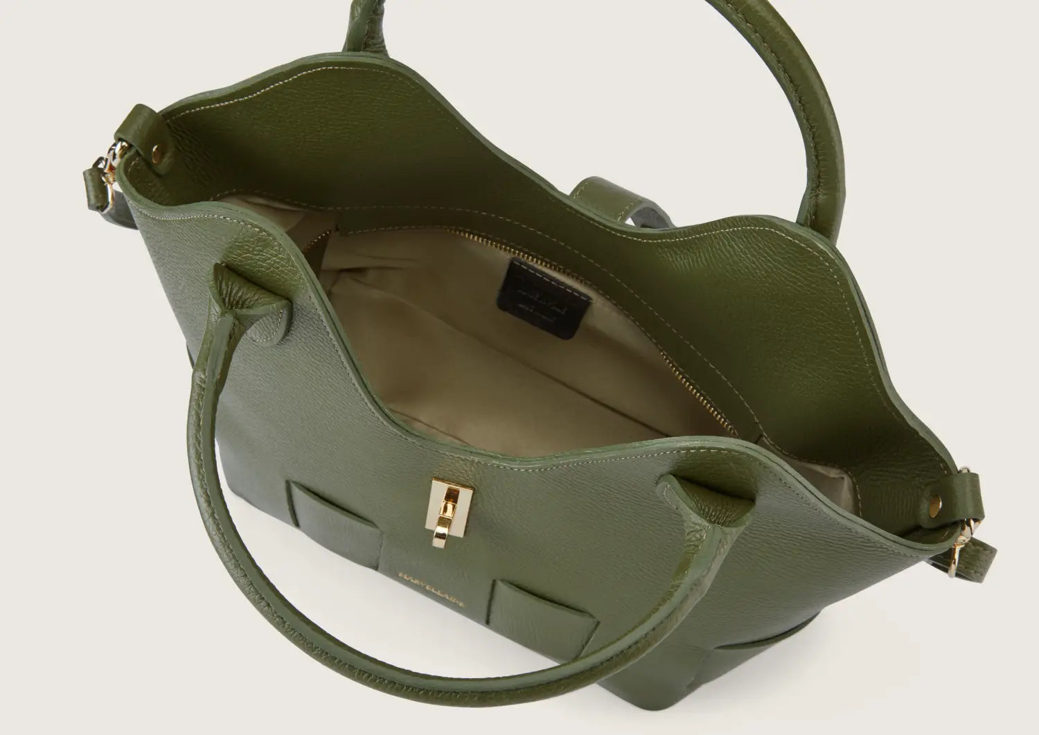 Close-up of the army green leather handbag highlighting the sturdy top zip closure with metallic accents.