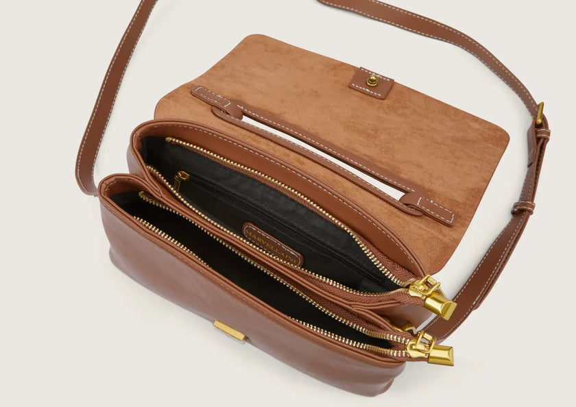 Close-up of the leather crossbody bag featuring a secure zip closure.
